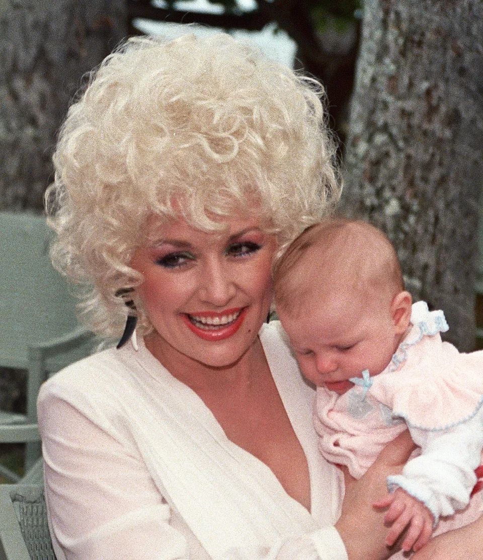Dolly Parton z dojenčkom v Honoluluju na Havajih leta 1983. Svojih otrok ni imela.